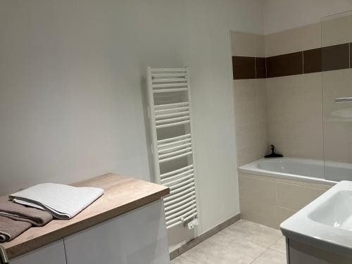 Appartement de charme + parking centre-ville Arras في أراس: حمام أبيض مع حوض وحوض استحمام