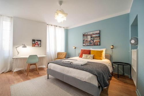 - une chambre avec un lit aux murs bleus et un bureau dans l'établissement Mâcon Cozy / Appartement central 100m² / 8 pers, à Mâcon