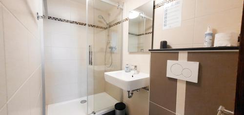 ein Bad mit einer Dusche, einem Waschbecken und einer Dusche in der Unterkunft Gasthof Alte Schule in Fürstenzell