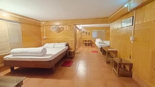 Habitación con 2 camas y escritorio. en SDD Bamboo Village Resort en Uttar Simlabari
