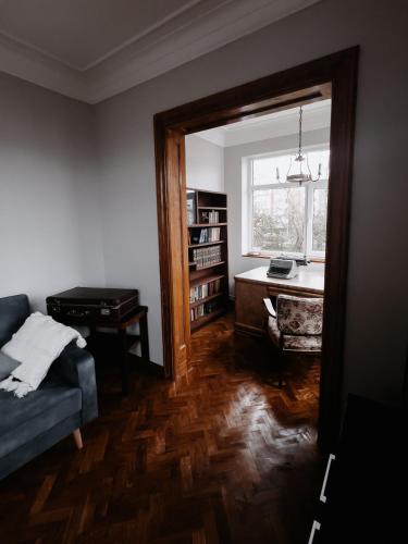 uma sala de estar com um sofá, uma secretária e uma janela em Vintage apartment Ranne em Riga