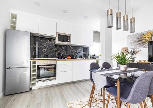 a kitchen with white cabinets and a table and chairs at Casa do Mar / Villa Eira Nova in Porto Covo