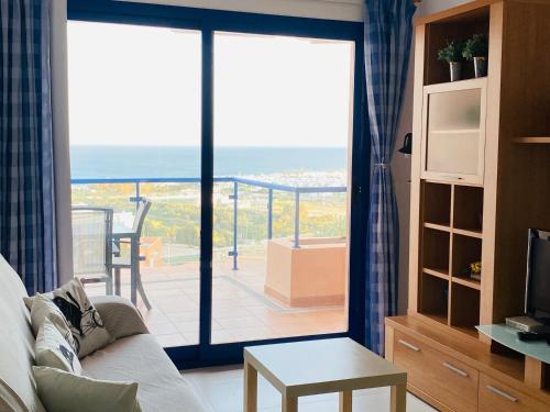 een woonkamer met een glazen schuifdeur en een balkon bij SUNRISE ATALAYA Amanecer suite in Mojácar
