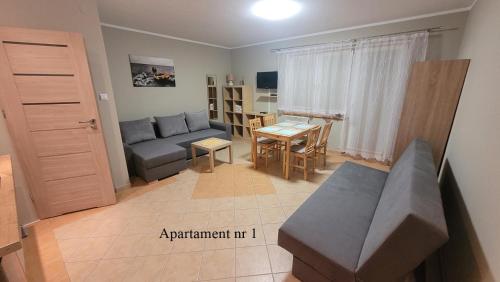 a living room with a couch and a table at Apartament Rybacka 84m1 in Krynica Morska