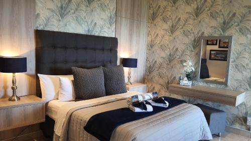 a bedroom with a large bed and a mirror at Amelia's by the Sea in Groot Brak Rivier