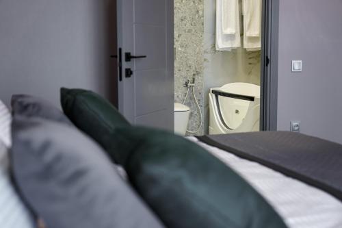a bedroom with a bed and a bathroom with a toilet at Dynasty Hotel & SPA in Yerevan