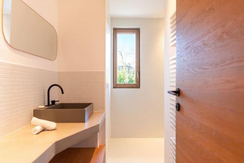 une salle de bain avec un lavabo et une fenêtre dans l'établissement Villa Tegghiacciu*vue mer*pisicne, à Sari-Solenzara