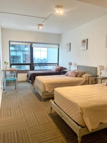 a bedroom with three beds and a window at Obelisco 818 in Buenos Aires