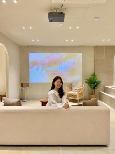 a woman sitting on a couch in front of a screen at Poolvilla Gaon in Busan
