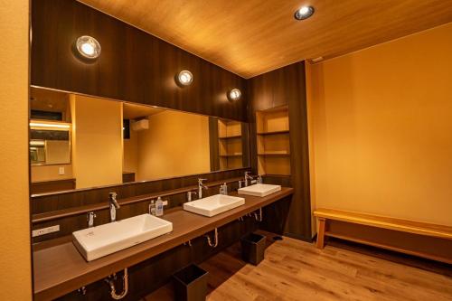 baño con 3 lavabos y espejo grande en ホテル大藏, en Kanoya