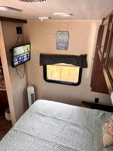 a bedroom in an rv with a bed and a tv at Garden Paradise RV Camper near Clearwater Beaches in Largo