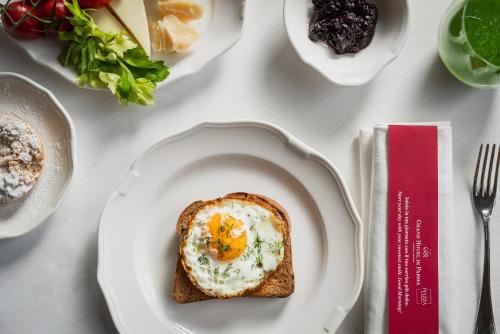 a white plate with an egg on a piece of toast at Grand Hotel di Parma | UNA Esperienze in Parma
