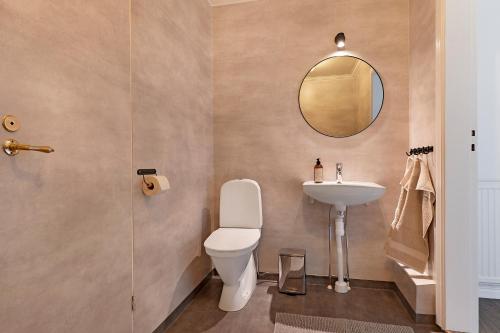 La salle de bains est pourvue de toilettes et d'un lavabo. dans l'établissement Guestly Homes - 4BR Charming Apartment, à Roknäs