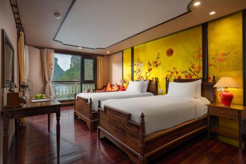 a bedroom with two beds and a fireplace in it at Indochine Cruise Lan Ha Bay in Ha Long