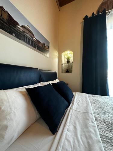 ナポリにあるMansarda Valù B&Bのベッドルーム1室(ベッド1台、白黒の枕付)