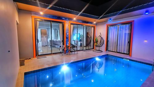 una piscina in una casa con finestre di NKR Poolvilla a Ban Don