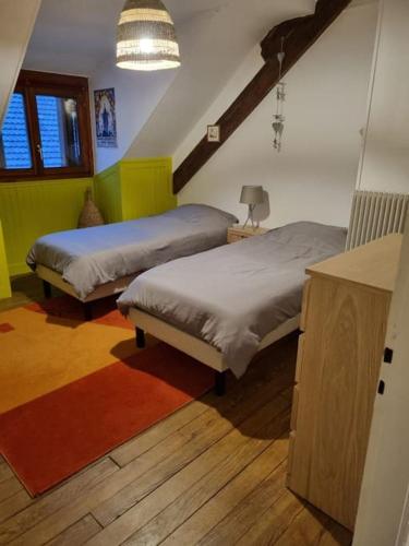 une chambre avec deux lits et une table avec une lampe dans l'établissement Appartement centre-ville (Chez Antoine), à Colmar
