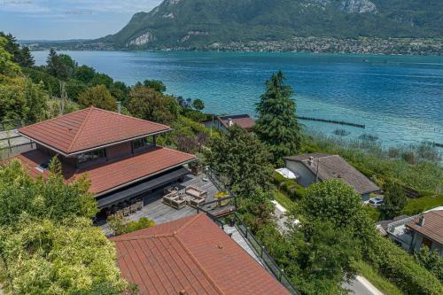 une vue aérienne sur une maison à côté de l'eau dans l'établissement Lac d'Annecy villa d'exception avec accès au lac : Villa Hollywood, à Sévrier