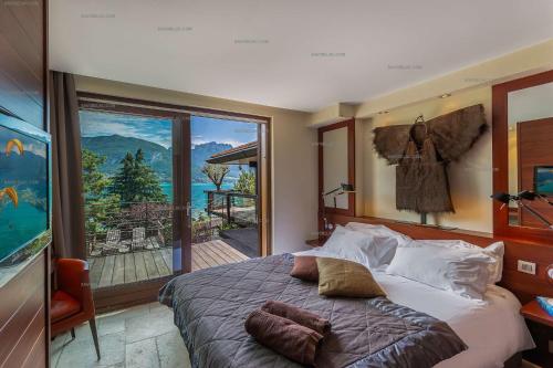 une chambre avec un grand lit et une grande fenêtre dans l'établissement Lac d'Annecy villa d'exception avec accès au lac : Villa Hollywood, à Sévrier