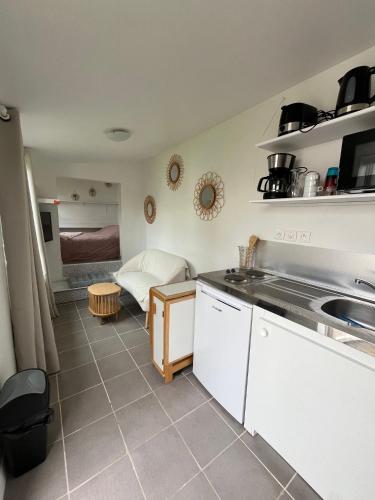 une cuisine avec un évier et une chambre avec un lit dans l'établissement Lalyne- Maison de charme et son studio Trouville sur mer, à Trouville-sur-Mer