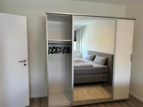 1 dormitorio con 1 cama en un armario con espejo en Ferienwohnung Kassel City, en Kassel