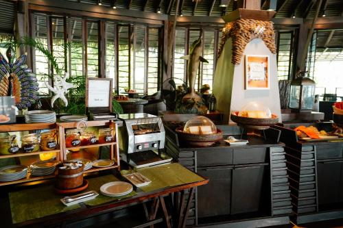 a kitchen with a counter with plates and food at Panviman Resort Koh Phangan in Thong Nai Pan Noi
