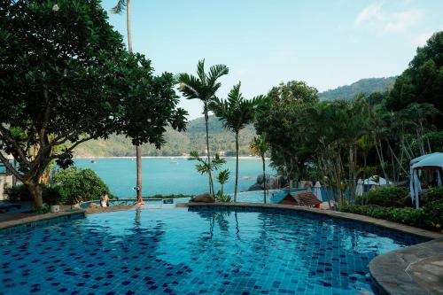 a large swimming pool with a view of the water at Panviman Resort Koh Phangan in Thong Nai Pan Noi