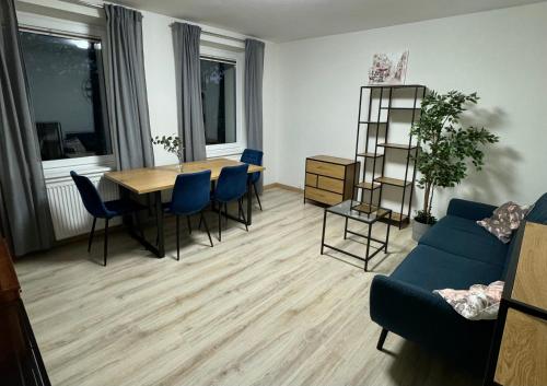 ein Wohnzimmer mit einem Tisch und einem blauen Sofa in der Unterkunft Cozy Apartment Wrzeszcz free parking! in Danzig