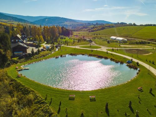 an aerial view of a pond in a green field at Oravský Háj Garden Hotel & Resort in Trstená
