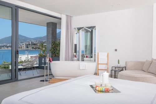 a white bedroom with a tub and a couch at Akana Loft in Bodrum City