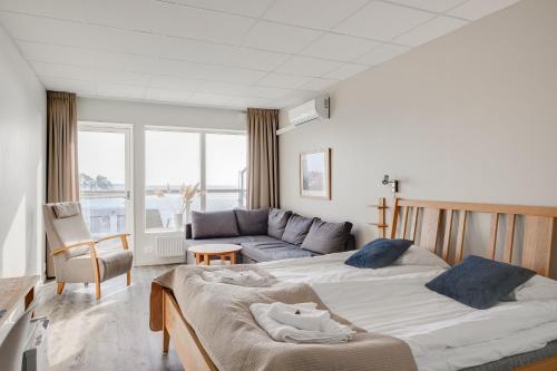 een slaapkamer met 2 bedden en een bank bij Hotell Hamnen in Färjestaden