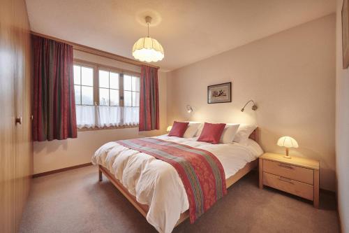 a bedroom with a large bed and a window at Chalet Panorama 1 in Wengen