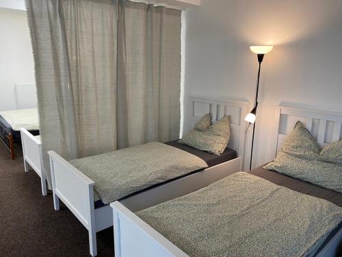 a bedroom with two twin beds and a window at Ubytování Šantovka in Olomouc