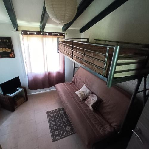 - une chambre avec des lits superposés et un canapé dans l'établissement Maison bord de mer, à Penta-di-Casinca