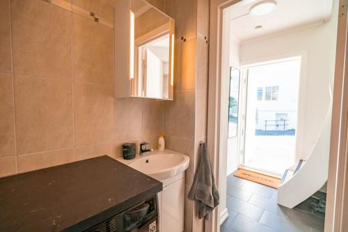ein kleines Bad mit einem Waschbecken und einem Fenster in der Unterkunft Dinbnb Apartments I Skansen funhouse! Gym, outdoor-area & location! in Bergen
