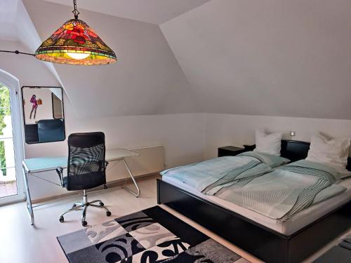 Altstadt的住宿－2 bedrooms apartement with enclosed garden and wifi at Limbach Kirkel，一间卧室配有一张床、一张桌子和一把椅子