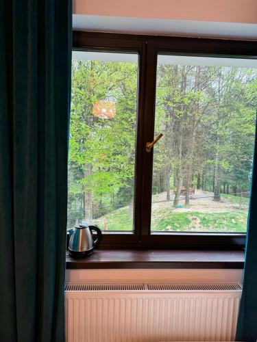 a window with a tea pot sitting on a window sill at Villa Vincentów in Myślenice