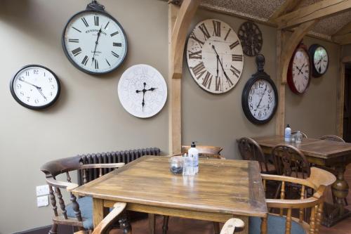 um quarto com relógios na parede e uma mesa em The Wheatsheaf Inn em Kendal