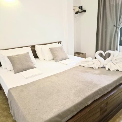 a bedroom with two beds with white sheets and two hearts at Mamma Mia Villa and Cafeteria in Unawatuna