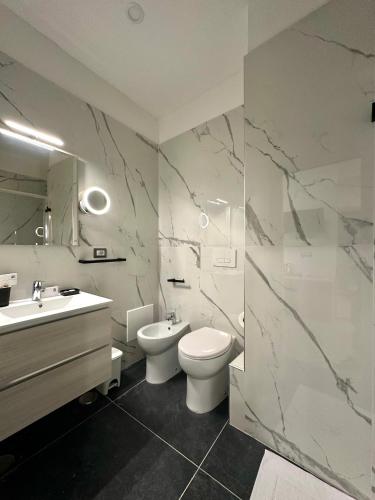 a bathroom with a sink and a toilet and a mirror at B&B Smart Station Caserta in Caserta