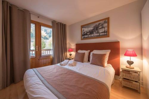 une chambre avec un grand lit et une fenêtre dans l'établissement La Clusaz Primevères Été, à La Clusaz