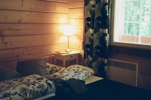 1 dormitorio con cama, lámpara y ventana en Fish & Fun Holiday Village, en Paaso