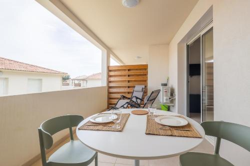une salle à manger avec une table et des chaises blanches dans l'établissement Linguizzetta - studio climatisé - piscine partagée, à Linguizzetta