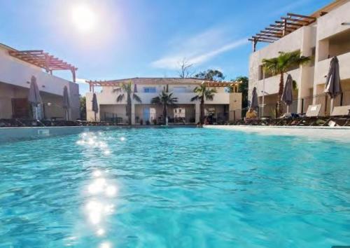 une grande piscine devant certains bâtiments dans l'établissement Linguizzetta - studio climatisé - piscine partagée, à Linguizzetta