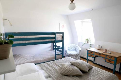 1 dormitorio con litera azul y silla en Agda Lund Bed & Breakfast, en Kivik