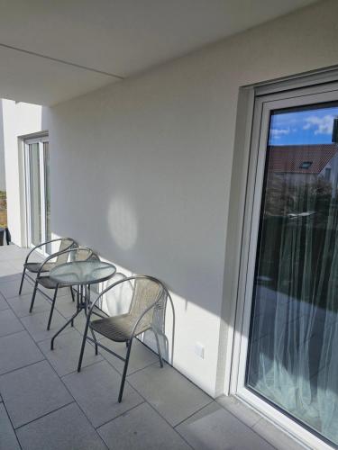 3 Stühle und ein Tisch auf dem Balkon in der Unterkunft Apartment Weikersheim V in Weikersheim
