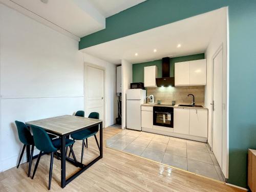 une cuisine et une salle à manger avec une table et des chaises dans l'établissement Le Green Lodge, à Nevers