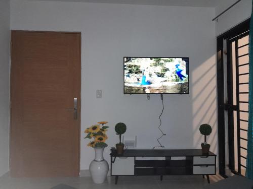 ein Wohnzimmer mit einem TV an einer weißen Wand in der Unterkunft Res Quintas Palmeras IV in Santiago de los Caballeros