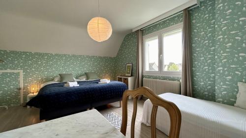 ein Schlafzimmer mit grüner Tapete, einem Bett und einem Fenster in der Unterkunft Maison avec jardin: La cabane aux oiseaux in Saint-Valery-sur-Somme