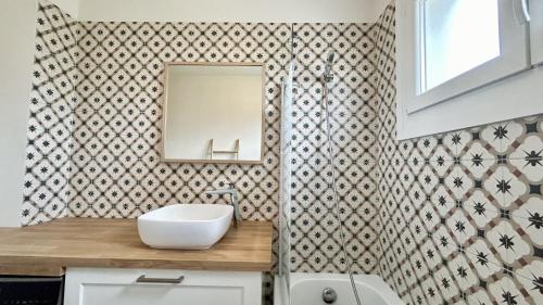 ein Bad mit einem Waschbecken und einem Spiegel in der Unterkunft Maison avec jardin: La cabane aux oiseaux in Saint-Valery-sur-Somme